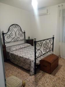 B&B ca'del grillo في Castel del Rio: غرفة نوم بسرير اسود وطاولة خشبية