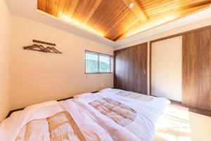 a bedroom with a large bed with a wooden ceiling at 郷隅美悦 - Kyo Gu Bi Etsu in Hakone