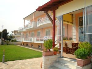 a large apartment building with a patio and lawn at Pension Delfini in Asprovalta