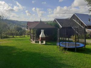 um quintal com um gazebo e um trampolim em Pokoje gościnne u Kaski em Krościenko