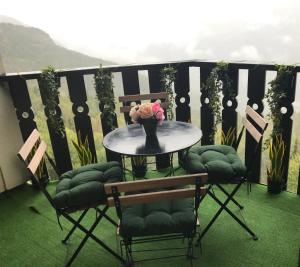 een tafel en stoelen met een vaas met bloemen op een balkon bij au Bonheur - Praloup 1600 - Au cœur de la station et au pied des pistes - La voile des neiges - parking commun privé - local ski in Pra-Loup