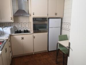 a kitchen with white cabinets and a white refrigerator at Apartamento duplex vacacional in Arenys de Mar
