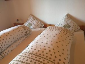 two beds with pillows on them in a bedroom at Chalet Garnedel in Breil/Brigels