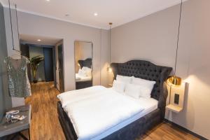 una camera con un grande letto e uno specchio di Munich Rooms Hotel a Monaco