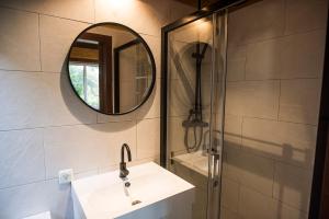 a bathroom with a sink, mirror, and shower stall at Casa Castor, Fábrica, Cacela Velha. in Vila Nova De Cacela