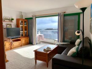 a living room with a couch and a large window at La Playa in Órzola