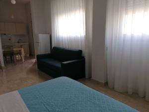 a living room with a couch and a chair at Zibibbo Beach Apartments - Trapani in Trapani