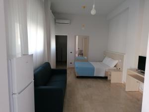 a bedroom with a bed and a couch and a television at Zibibbo Beach Apartments - Trapani in Trapani
