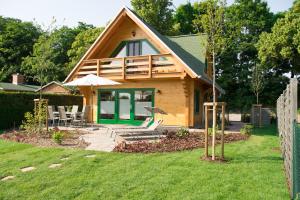 a house with a deck and chairs in the yard at Ferienhaus F.Winkler in Neukalen