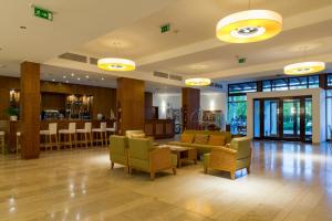 a lobby with couches and chairs and a bar at Tisza Balneum Hotel in Tiszafüred