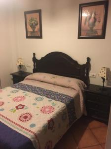 a bedroom with a bed with a floral comforter at El Escondite de Myriam in Grazalema
