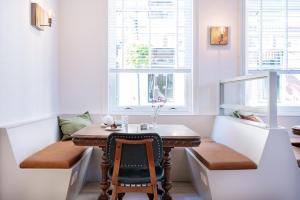 a small dining room with a table and two windows at Boutique Hotel - de Stadsherberg Alphen in Alphen aan den Rijn