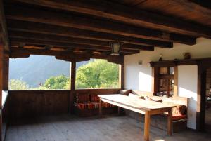 salon ze stołem i dużym oknem w obiekcie Къща за гости Кануш войвода w mieście Kovachevitsa