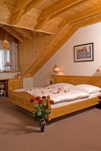 a bedroom with a wooden bed with a vase of flowers at Hotel Zum Fischerwirt in Baindlkirch