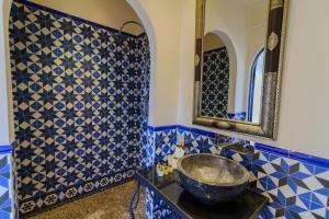 baño azul y blanco con lavabo y espejo en Las Orquideas Hotel Spain en Los Romanes