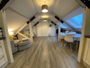 a living room with a table and chairs in a attic at Nera Stay in Leighton Buzzard