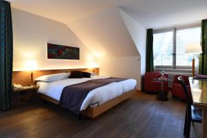 a bedroom with a bed and a dresser at Hotel & Restaurant STERNEN MURI bei Bern in Bern