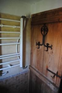 a bathroom with a wooden wall with a cross on it at Къща за гости Кануш войвода in Kovachevitsa