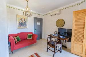 a living room with a red couch and a desk at Las Orquideas Hotel Spain in Los Romanes