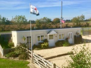 a flag flying in front of a white house at Runway Cottage in Coningsby