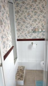 a bathroom with a toilet and floral wallpaper at Hollingworth Lake Guest House Room Only Accommodation in Littleborough