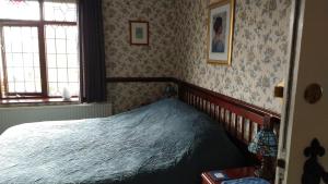a bedroom with a bed in a room with wallpaper at Hollingworth Lake Guest House Room Only Accommodation in Littleborough