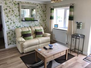 een woonkamer met een bank en een salontafel bij Runway Cottage in Coningsby