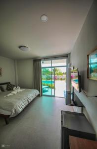 a bedroom with a bed and a view of a pool at Lotus Lake View in Ban Bua