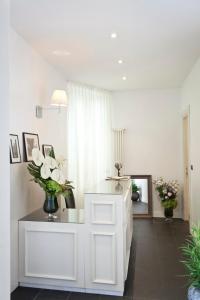 a white room with a vase of flowers on a counter at Garibaldi Suites Piazza Di Spagna in Rome