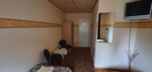 Zimmer mit einem Tisch und einem TV an der Wand in der Unterkunft Kure Guesthouse in Rahinge