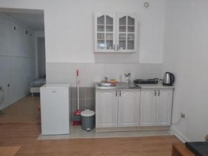 een keuken met witte kasten en een witte koelkast bij Sweet Dream Rooms in Podgorica