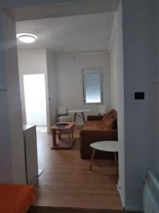 een woonkamer met een bank en een tafel bij Sweet Dream Rooms in Podgorica