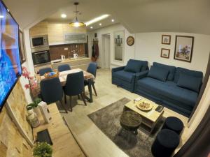 a living room with a blue couch and a table at Milmari RELAX apartment in Kopaonik