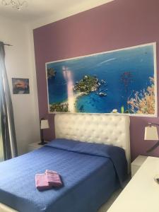 1 dormitorio con 1 cama con una pintura en la pared en Casa Bucalo, en Taormina
