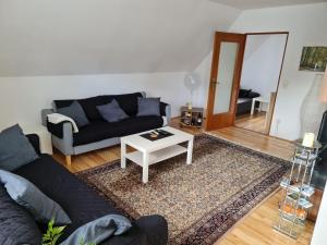 uma sala de estar com um sofá e uma mesa em Ferienwohnungen am Rumbachtal em Mülheim an der Ruhr