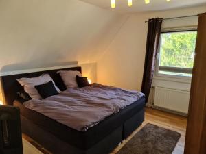 ein Schlafzimmer mit einem Bett in einem Zimmer mit einem Fenster in der Unterkunft Ferienwohnungen am Rumbachtal in Mülheim an der Ruhr
