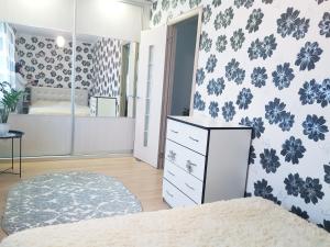 a bedroom with a bed and a dresser at Apartment on Zoe Kosmodemyanskoy in Pinsk