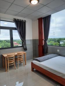 1 dormitorio con 1 cama, mesa y sillas en Hotel Sen Việt Bạc Liêu, en Bạc Liêu