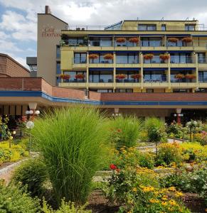 een gebouw met een bloementuin ervoor bij Hotel Graf Eberhard in Bad Urach