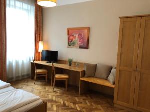 um quarto de hotel com uma secretária e uma cama em Gasthof Schwabl Wirt em Viena