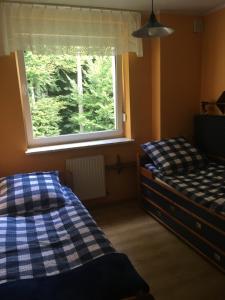 een slaapkamer met 2 aparte bedden en een raam bij Apartament Barbara in Szczyrk