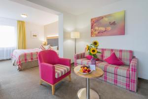 Eden Hotel في باد كروزنغن: غرفة معيشة مع أريكة وكرسي