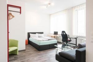 a living room with a bed and a chair at Apartmenthaus Aalen in Aalen