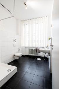 a white bathroom with a sink and a toilet at Apartmenthaus Aalen in Aalen