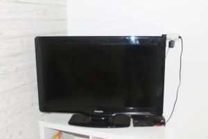 TV de pantalla plana en la parte superior de un puesto blanco en Malina - AND Apartment en Liptovský Mikuláš