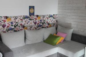 a couch with colorful pillows sitting in a room at Malina - AND Apartment in Liptovský Mikuláš