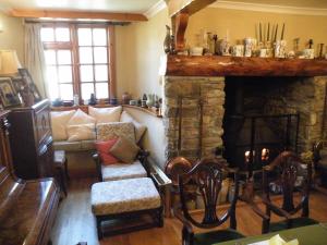 
a living room filled with furniture and a fireplace at Burton Farmhouse in Kingsbridge
