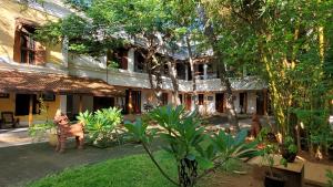 un patio de un edificio con árboles y plantas en Kariappa House en Pondicherry