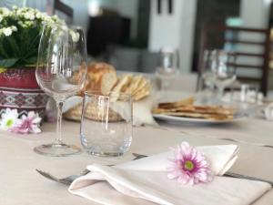 a table with wine glasses and a plate of food at Hotel Villa Cedrino in Dorgali