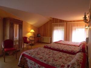 a hotel room with two beds and a table and chairs at Hôtel Picheyre in Formiguères